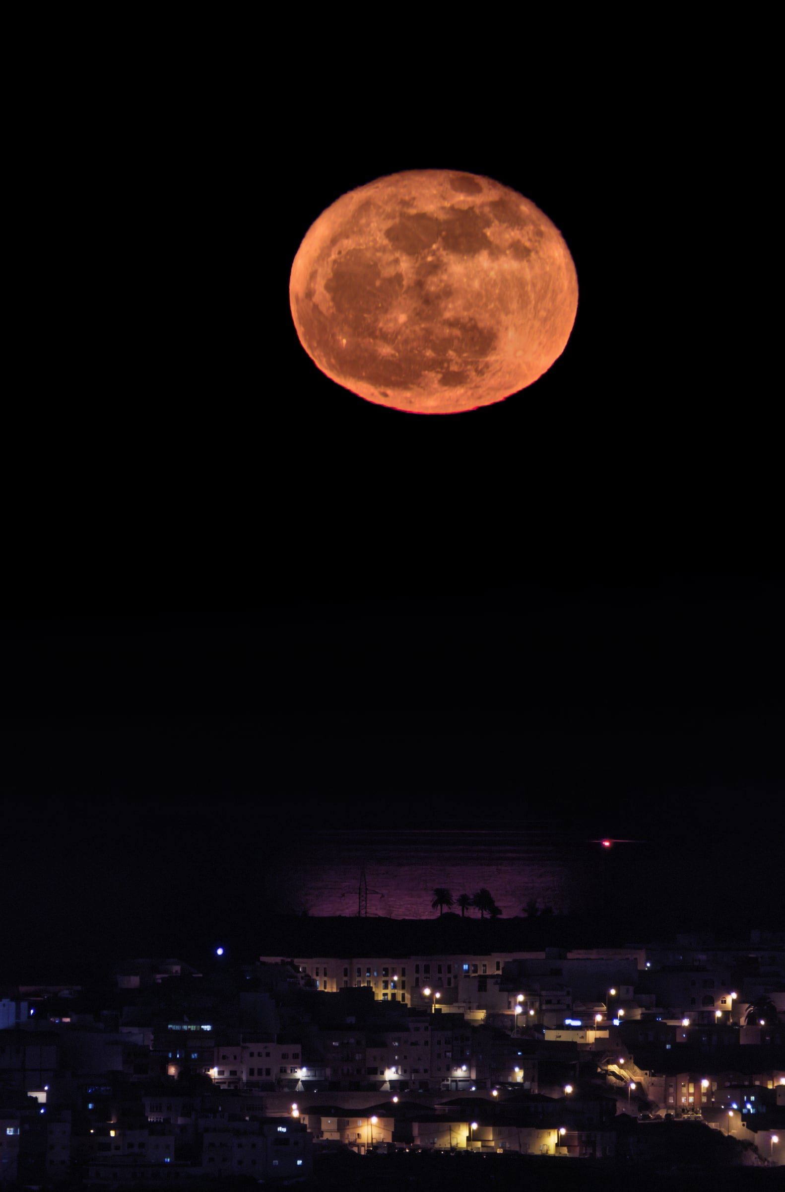 Luna llena de junio entre nubes al amanecer