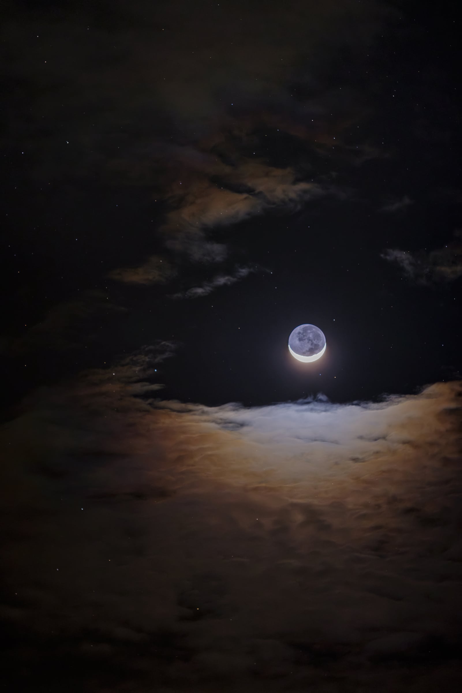 Luz cenicienta de la Luna entre nubes