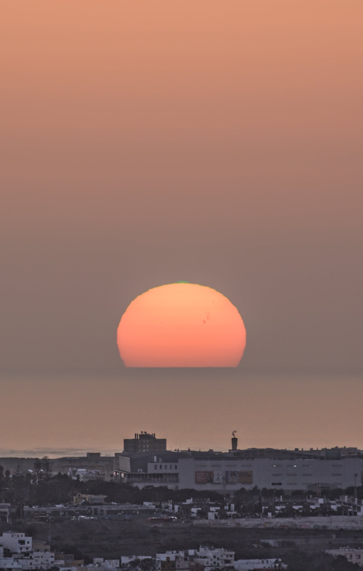 Rayo verde y manchas solares al atardecer sobre el Centro Comercial 7 Palmas